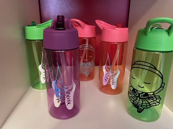 5 coloured drinking cups with dancer or shoes printed on front