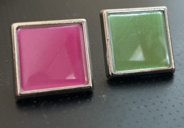 2 square pin badges in pink and green